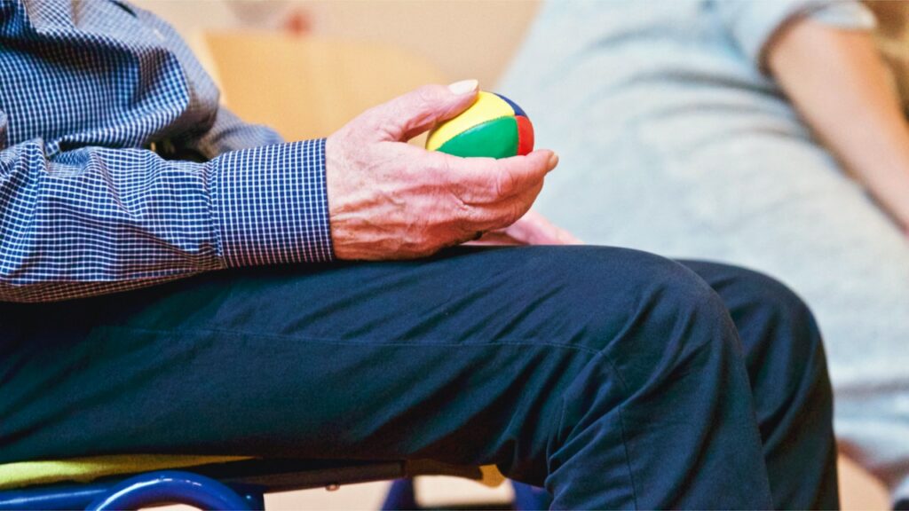older man holding a ball in physiotherapy